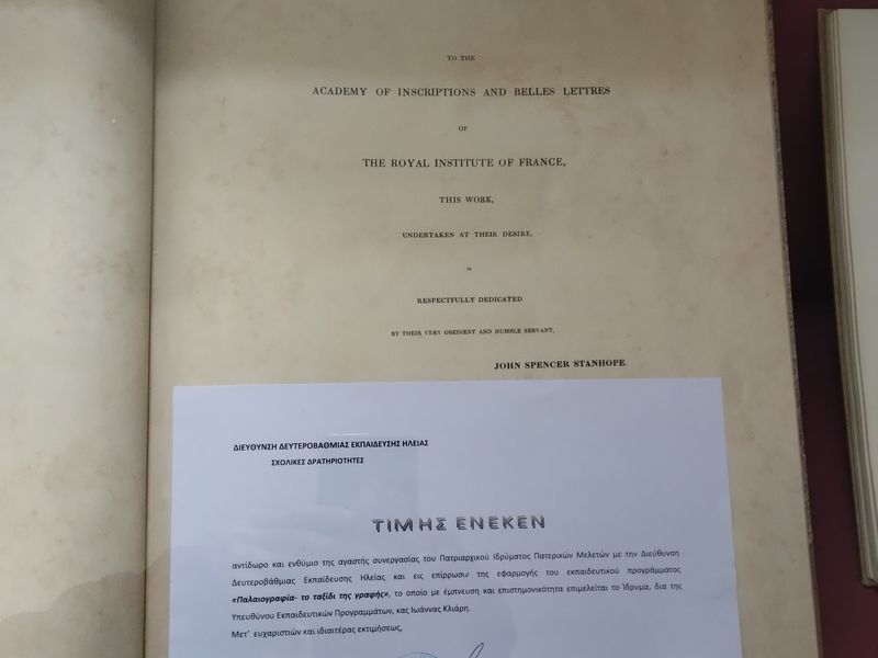 Έγγραφο με τίτλο «ΤΙΜΗΣ ΕΝΕΚΕΝ», σφραγίδα και υπογραφή καλύπτει μέρος μιας αγγλόγλωσσης αφιέρωσης βιβλίου.